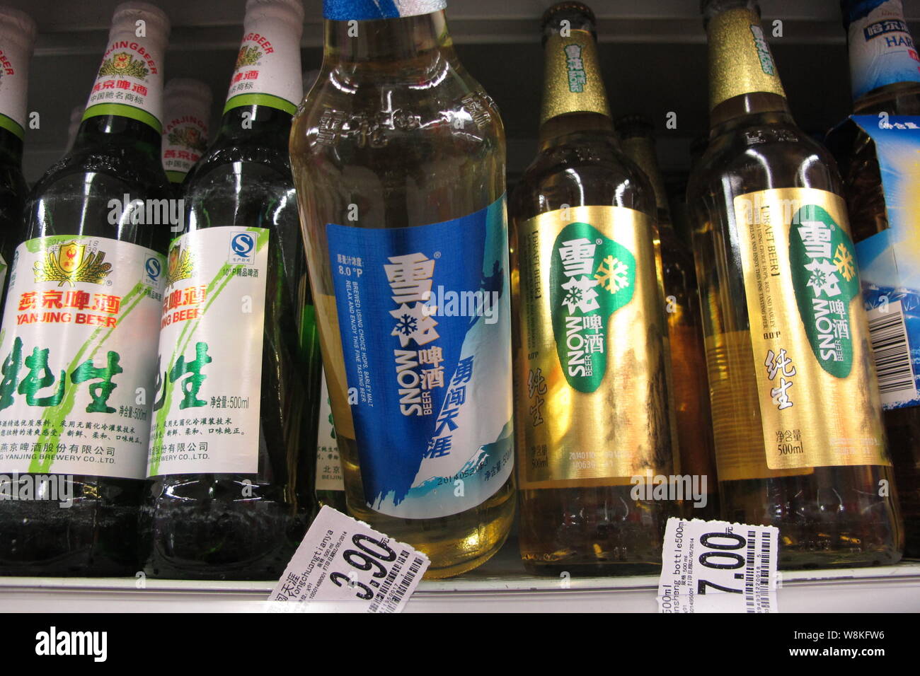 FILE--un cliente acquista una bottiglia di birra di neve della Cina risorse  Snow Breweries Ltd (CR) di neve in un supermercato a Yichang city, centrale  della Cina di Hubei Foto stock -