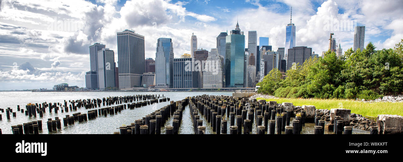 La città di New York New York Manhattan island skyline panorama vista panoramica. Banner del raccolto di waterfront lifestyle per pubblicità copyspace. Downtown cityscape dal ponte di Brooklyn Park Pier 1 Palude Salata. Foto Stock