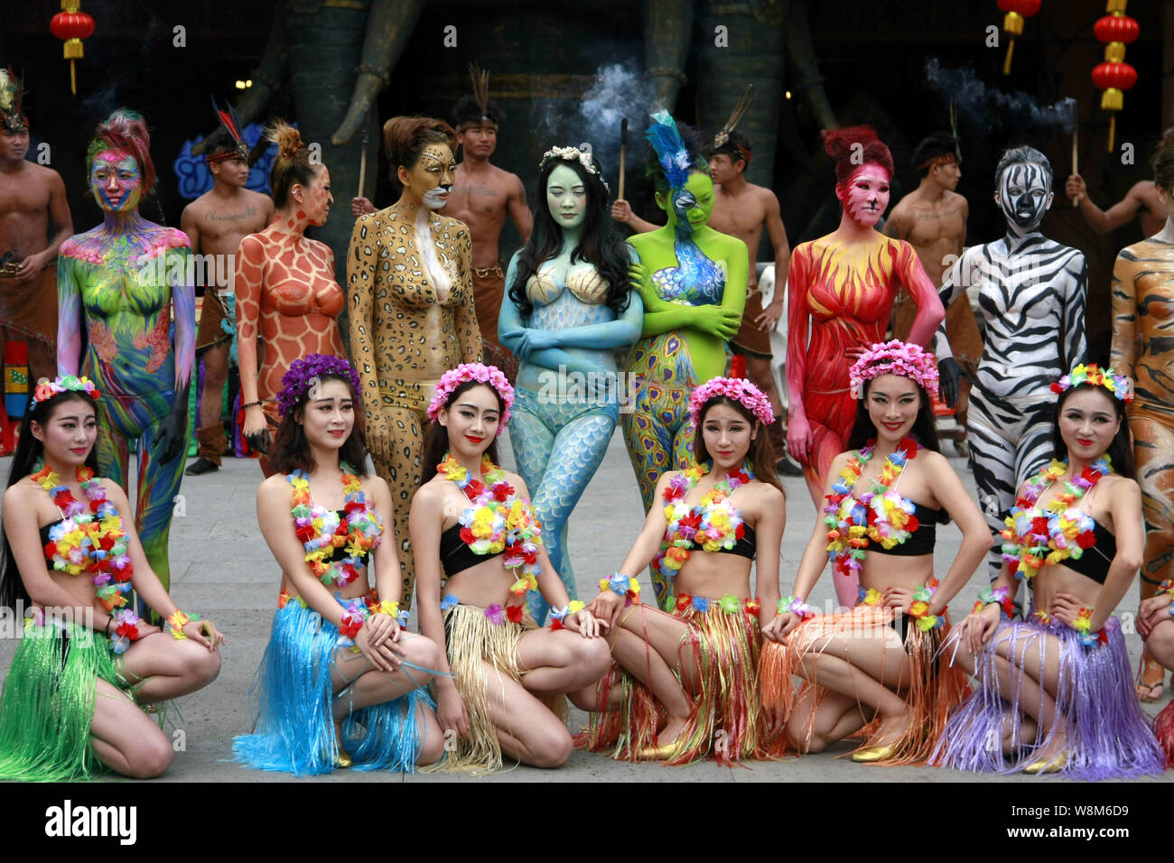 Modelli cinesi con sottoprodotti di origine animale-corpo a tema dipinti posano con altri animatori durante una campagna per la protezione degli animali a Sanya Zoo di colore nella città di Sanya Foto Stock