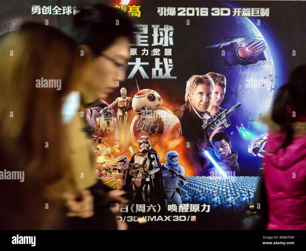 Filmgoers cinese a piedi passato un poster del film "Guerre Stellari: la forza risveglia' a un cinema in Cina a Shanghai, 1 gennaio 2016. Un luogo dove Foto Stock