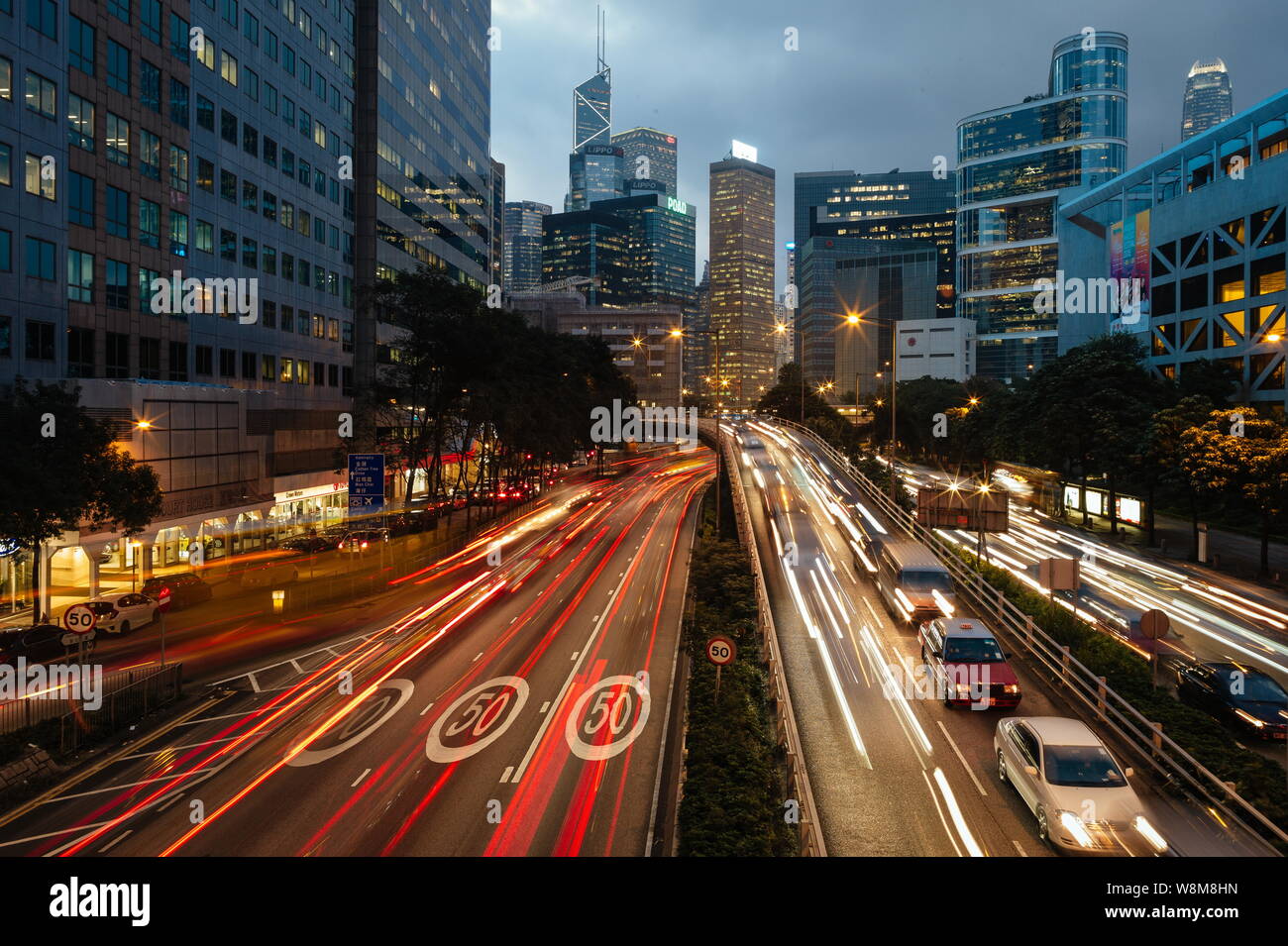Una vista notturna di vetture che viaggiano attraverso strade trafficate e un cavalcavia ponte in Admiralty, Hong Kong, Cina, dicembre 2015. Con l'impatto della internatio Foto Stock