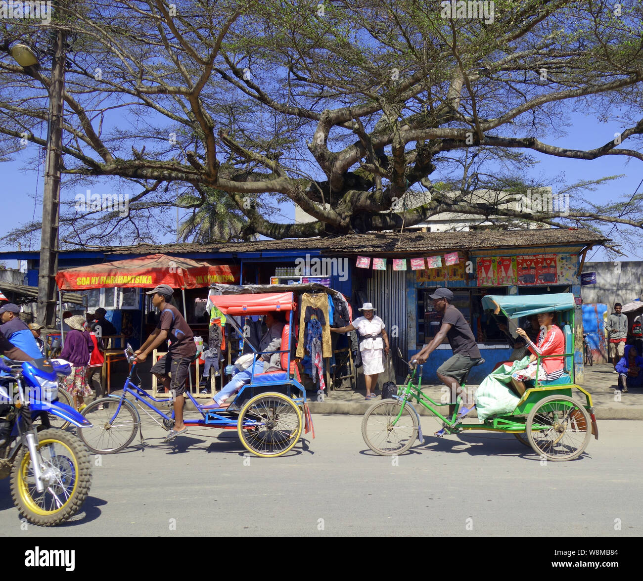 Strada principale trafficata con rickshaws e altro traffico, Moramanga, Madagascar. N. PR o MR Foto Stock
