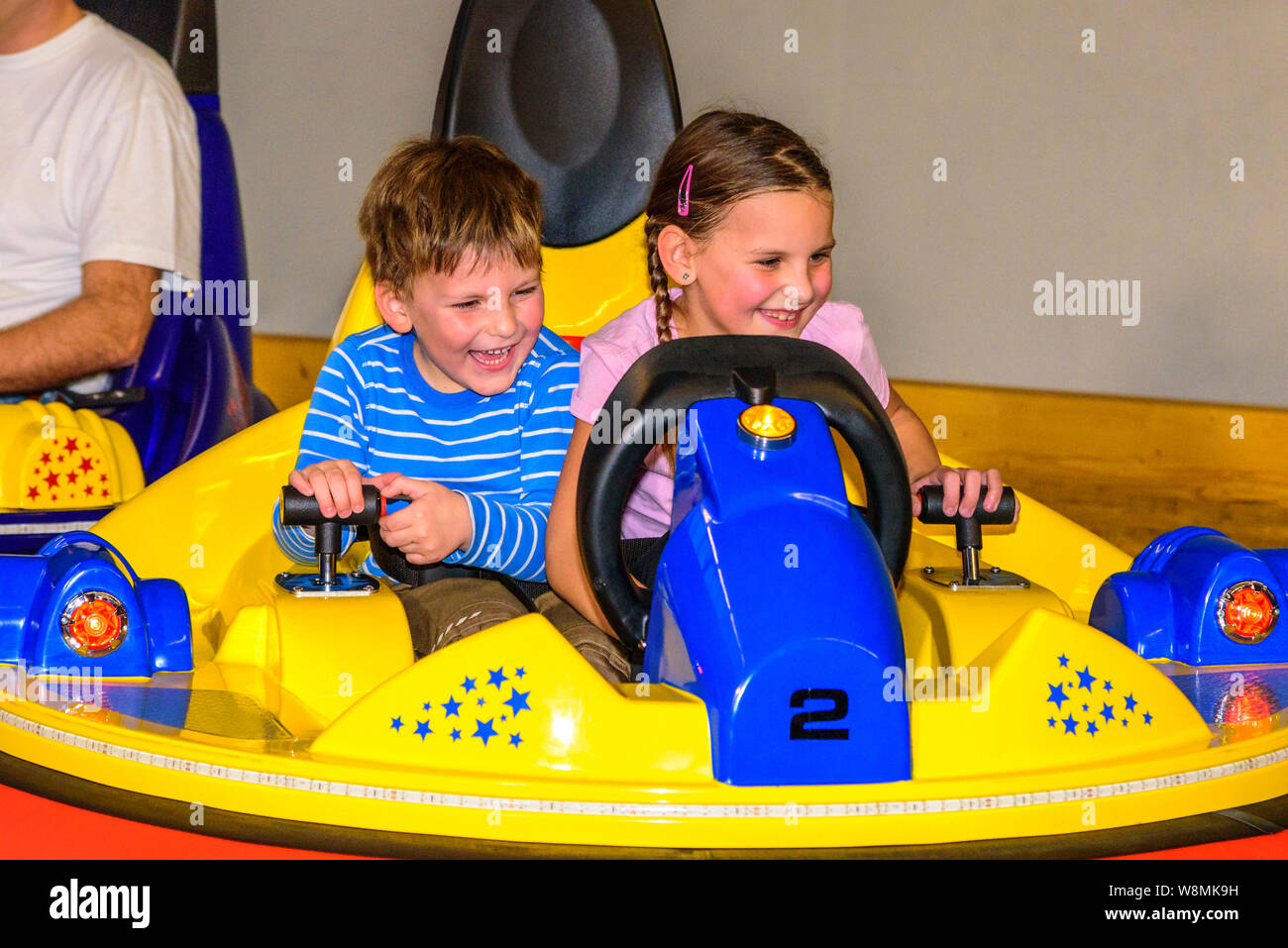 Scooter guida con i bambini nel parco giochi al coperto Foto Stock