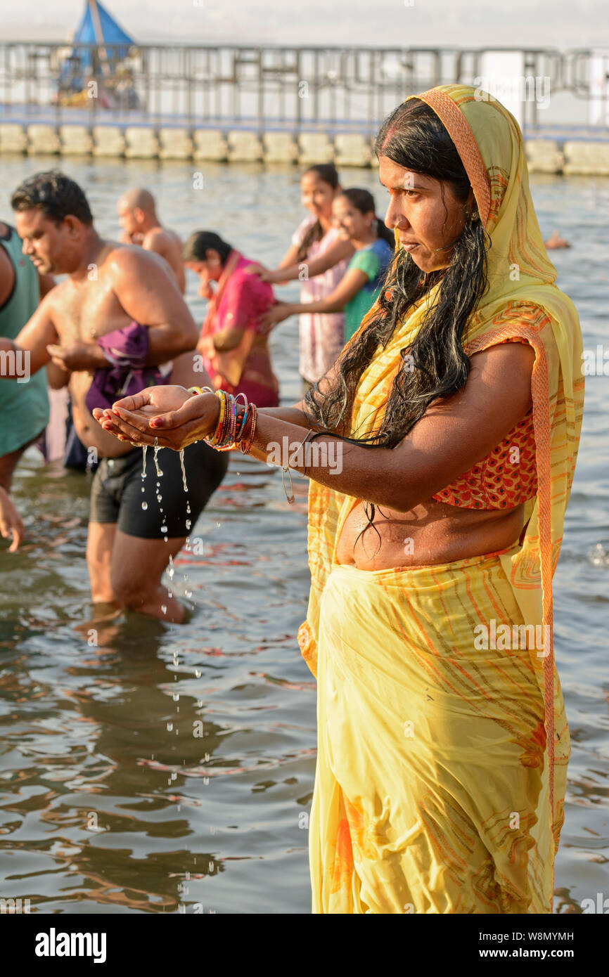 Un giovane indiano donna Indù che indossa un sari esegue una prima mattina rituale del bagno nel fiume Gange a Varanasi, Uttar Pradesh, India, Asia del Sud Foto Stock