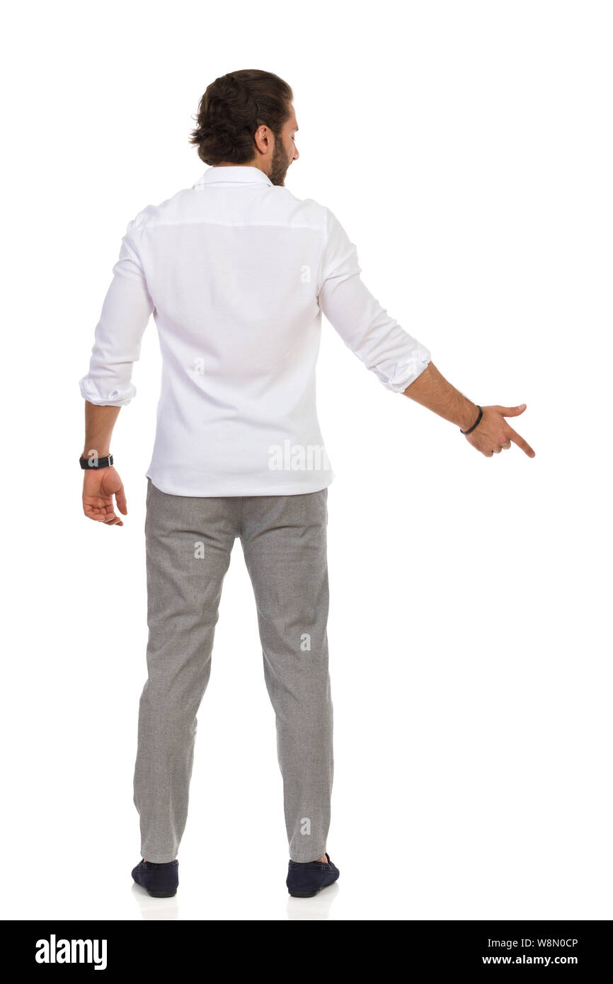 Bel uomo in grigio pantaloni e camicia bianca è permanente e la punta  rivolta verso il basso. Vista posteriore. Lunghezza completa studio shot  isolato su bianco Foto stock - Alamy