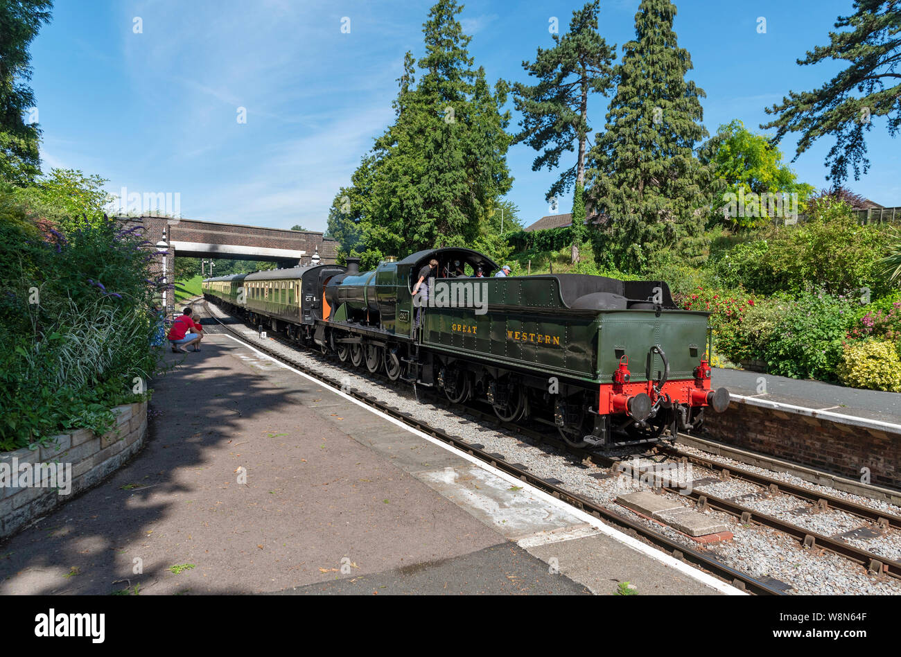 Winchcombe, Gloucestershire, Inghilterra, Regno Unito. Agosto 2019. Un motore a vapore carrelli di trascinamento attraverso la stazione di Winchcombe in Cotswolds regione Gloucest Foto Stock