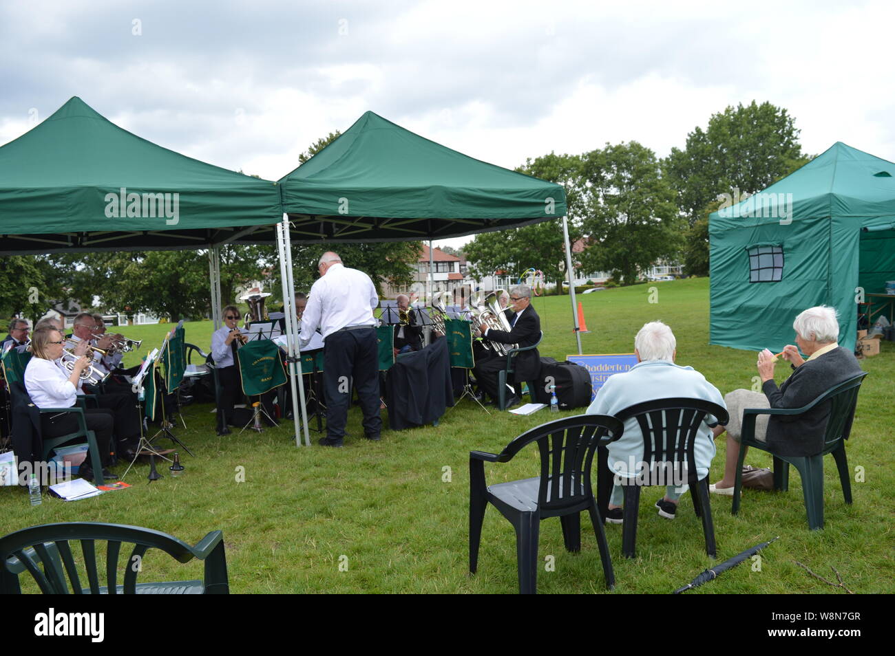 Anziani La riproduzione di uno strumento in un gruppo guidato da un vecchio in pensione orchestra presso Moston Manchester evento locale British Summer Time Foto Stock