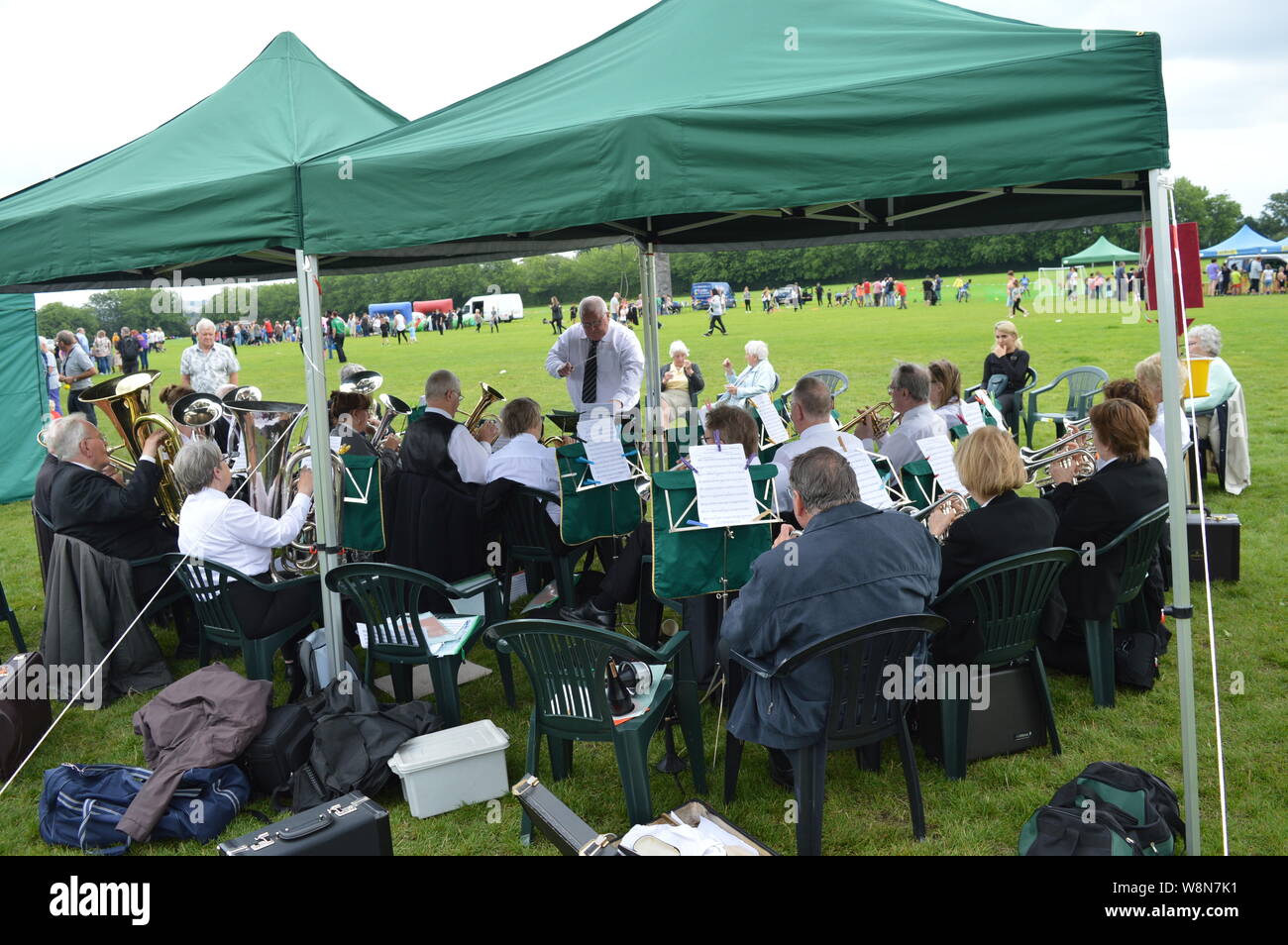 Anziani La riproduzione di uno strumento in un gruppo guidato da un vecchio in pensione orchestra presso Moston Manchester evento locale British Summer Time Foto Stock