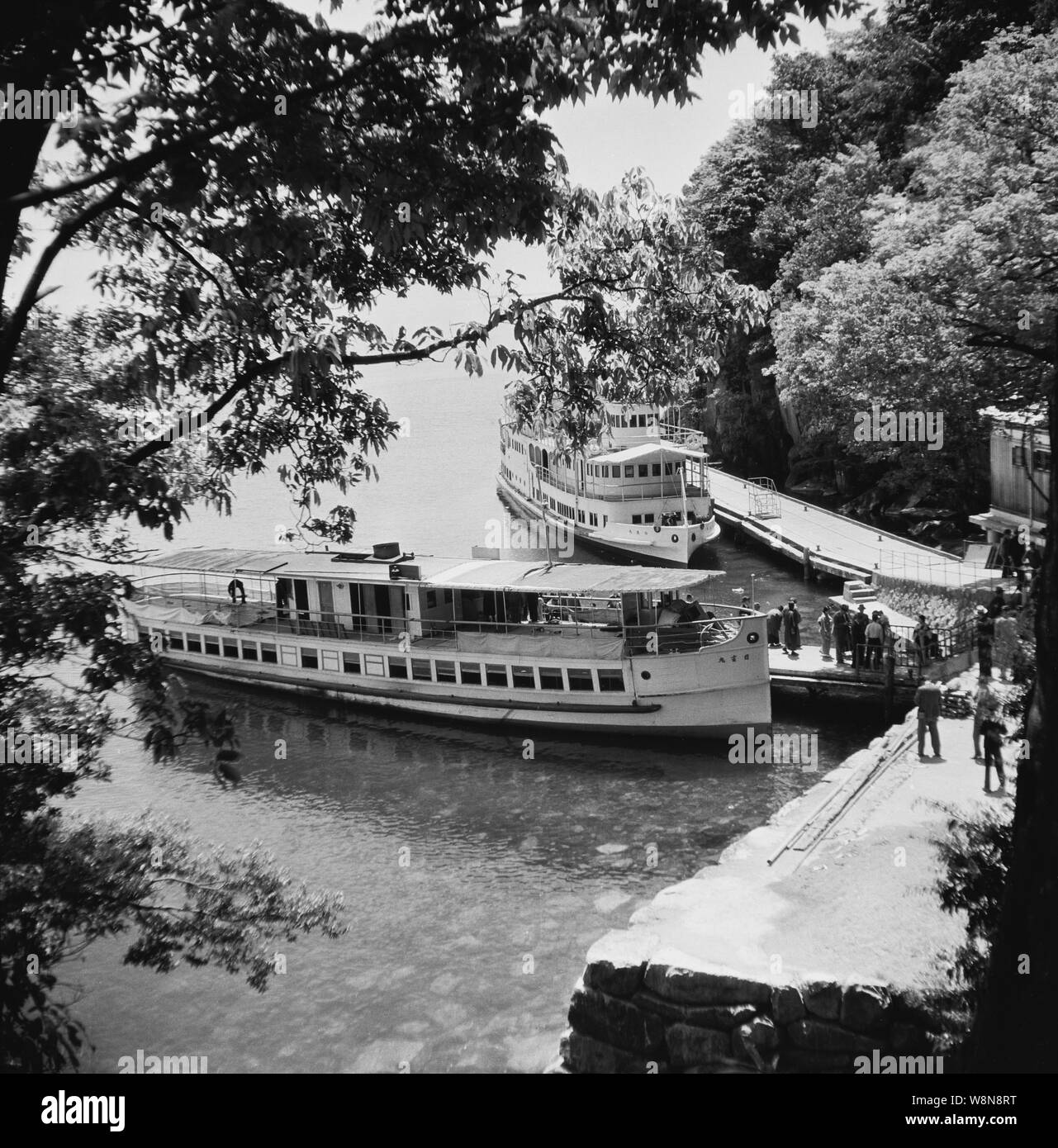 [ 1930 Giappone - nave da crociera sul Lago Biwa ] - Navi del Biwako Kisen Steamship Co.,Ltd., una società che organizza crociere e traghetti sul Lago Biwa nella prefettura di Shiga. La società è stata fondata nel 1869 (Meiji 2) ed è ancora oggi nel mondo degli affari. La nave sul retro di questa foto è il Hakucho Maru (Swan). Essa è stata completata come Momotaro Maru nel marzo 1927 (Showa 2), ma rinominato nel febbraio 1930 (Showa 5). Xx secolo vintage pellicola negativa. Foto Stock