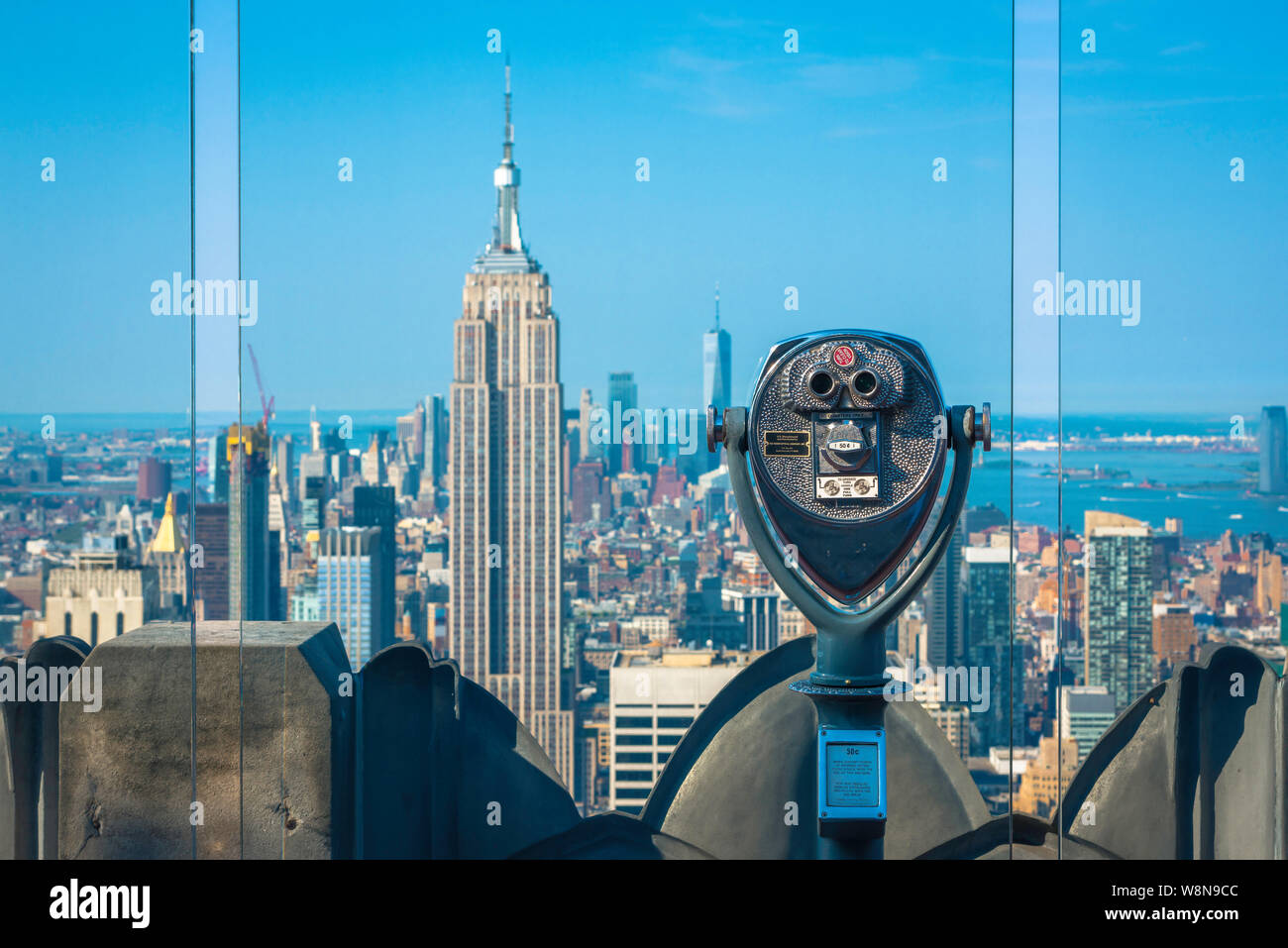 Midtown Manhattan, vista dalla piattaforma di osservazione del Rockefeller Center con l'Empire state Building visibile oltre gli schermi di vetro, New York City Foto Stock