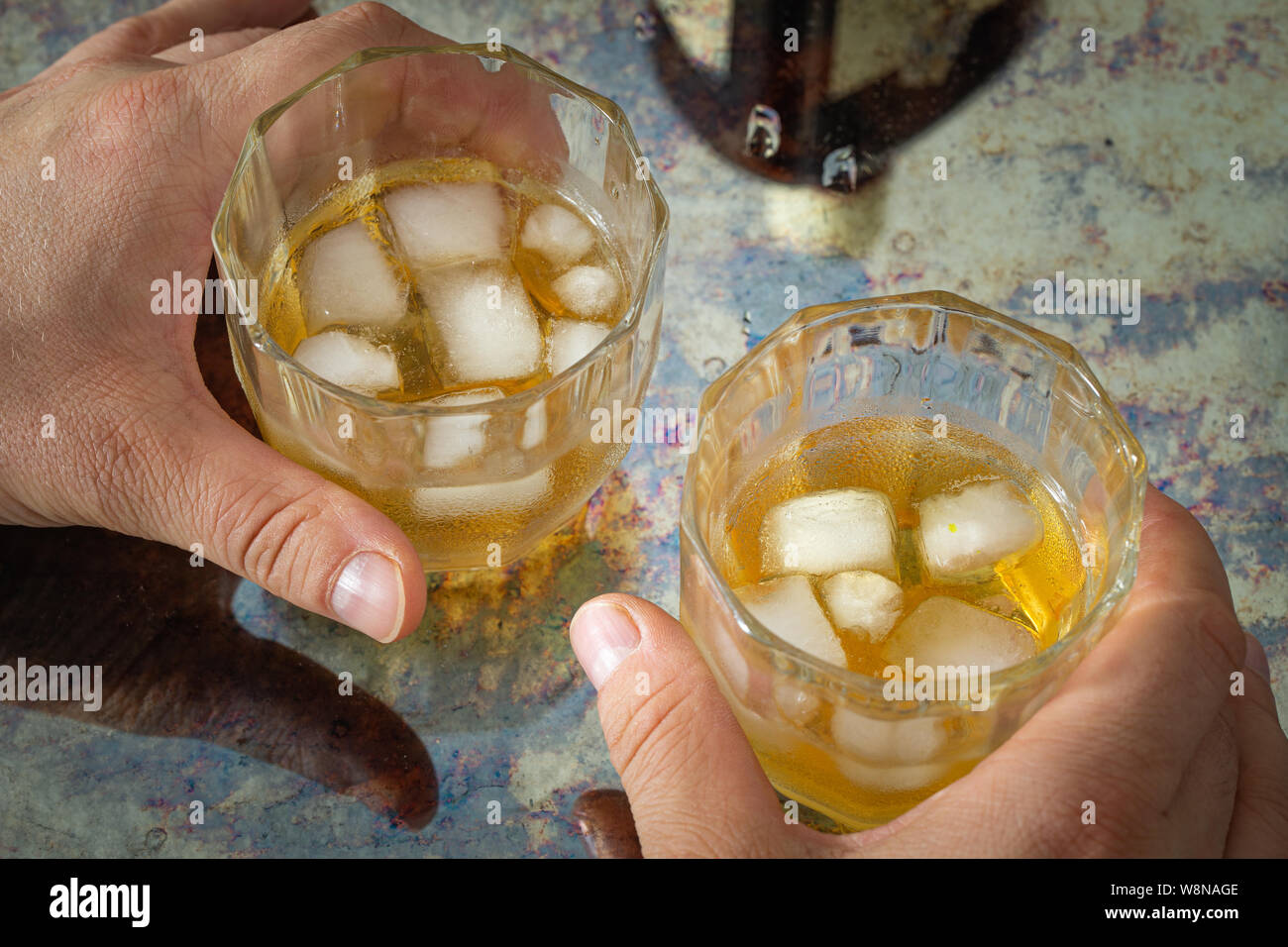 Bicchieri di alcol forte tenuta in mani. concetto di problemi di alcool e il consumo eccessivo di bevande alcoliche Foto Stock