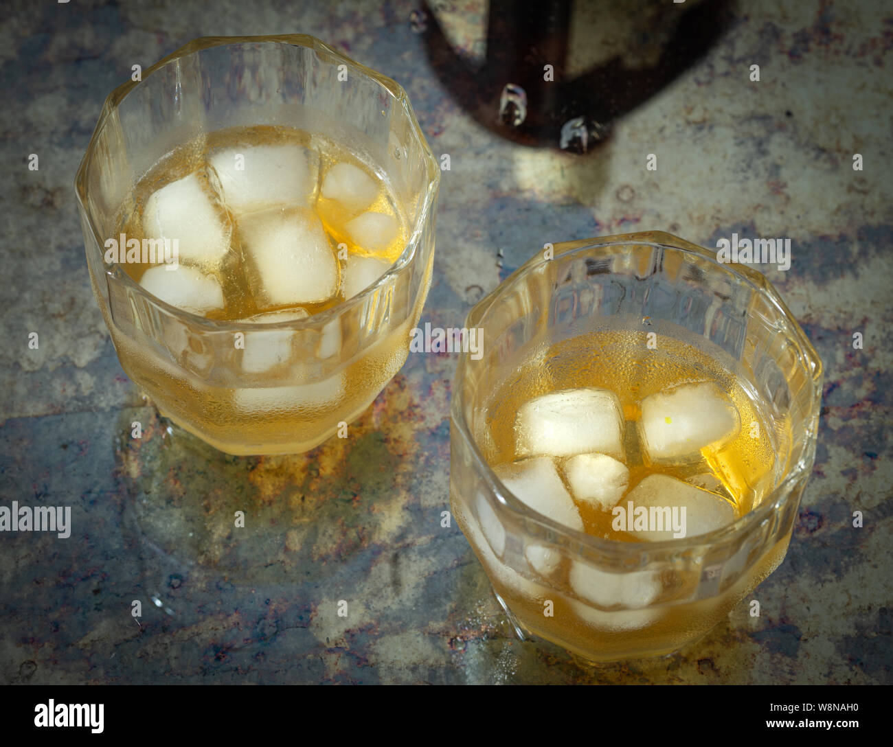Due bicchieri di whiskey con ghiaccio su un contatore ed elegante Foto Stock