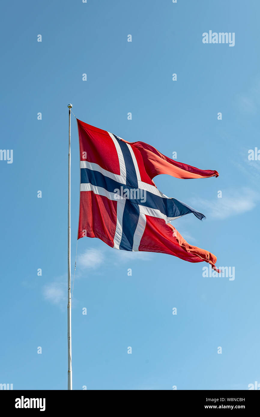 La bandiera norvegese che fluttua nel vento contro un Cielo di estate blu. Foto Stock