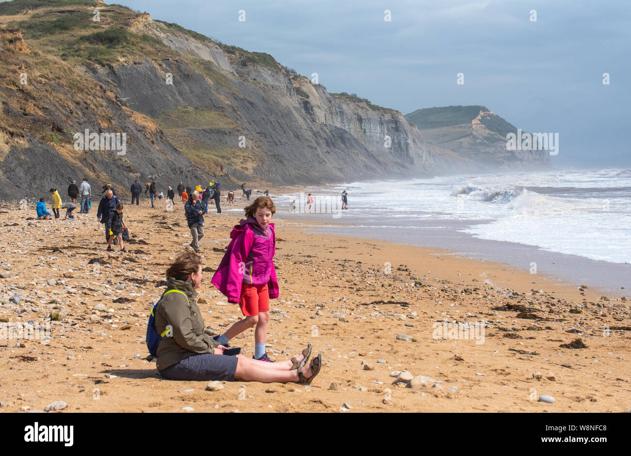 Charmouth, Dorset, Regno Unito. Il 10 agosto 2019. Meteo REGNO UNITO: vacanzieri avventurarvi in un blustery giornata al villaggio sul mare di Charmouth come unseasonably strong a sud-ovest si snoda continuano ad impasto lungo la costa sud occidentale il sabato pomeriggio. Le condizioni tempestose non scoraggiare i cacciatori di fossili sulla spiaggia Charmouth. Credito: Celia McMahon/Alamy Live News. Foto Stock