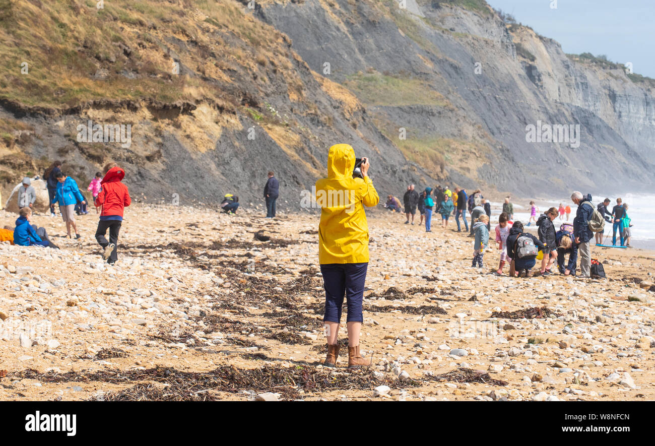 Charmouth, Dorset, Regno Unito. Il 10 agosto 2019. Meteo REGNO UNITO: vacanzieri avventurarvi in un blustery giornata al villaggio sul mare di Charmouth come unseasonably strong a sud-ovest si snoda continuano ad impasto lungo la costa sud occidentale il sabato pomeriggio. Le condizioni tempestose non scoraggiare i cacciatori di fossili sulla spiaggia Charmouth. Credito: Celia McMahon/Alamy Live News. Foto Stock
