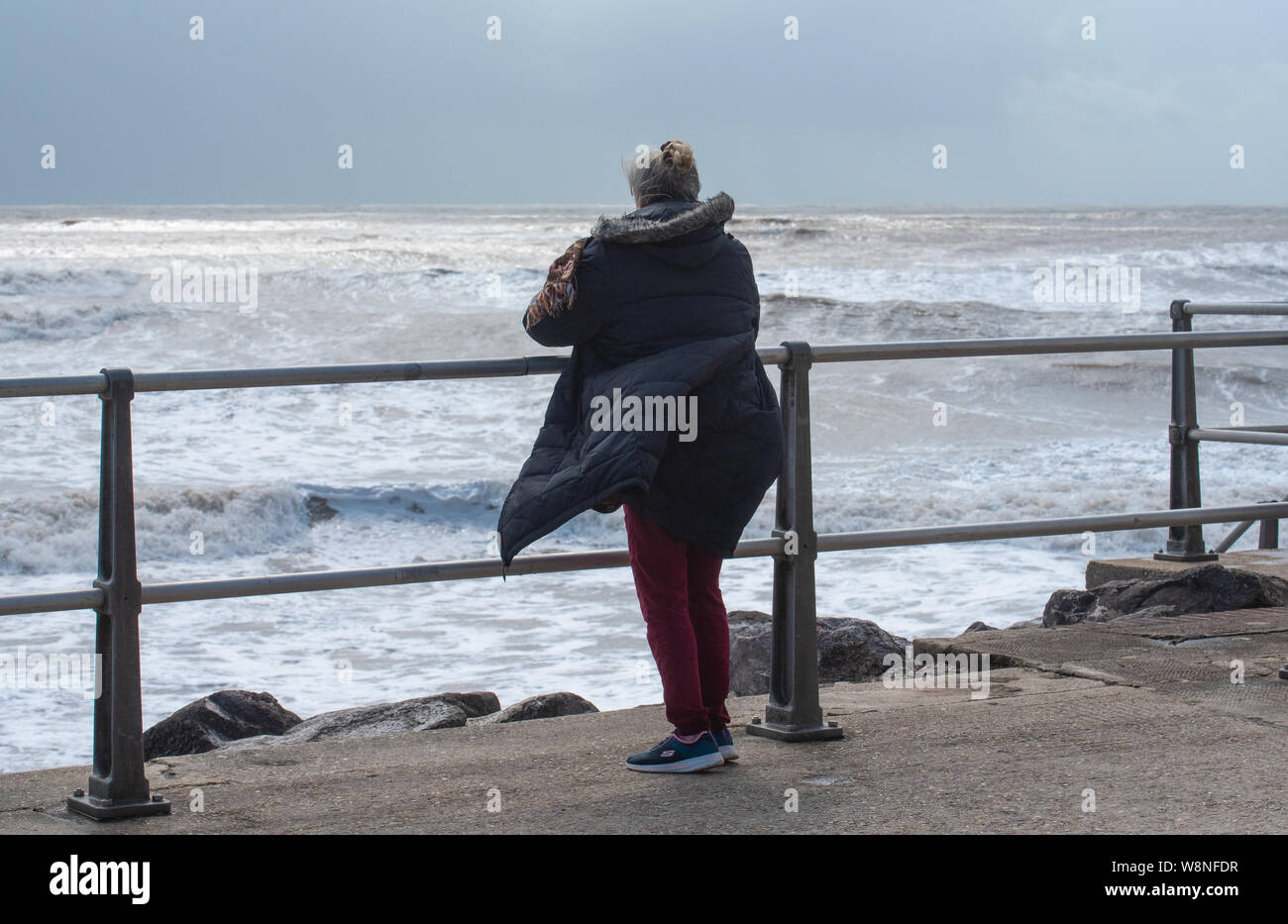 Charmouth, Dorset, Regno Unito. Il 10 agosto 2019. Meteo REGNO UNITO: vacanzieri avventurarvi in un blustery giornata al villaggio sul mare di Charmouth come unseasonably strong a sud-ovest si snoda continuano ad impasto lungo la costa sud occidentale il sabato pomeriggio. Warmings giallo per il vento ad alta velocità sono stati rilasciati attraverso il Sud Ovest. Credito: Celia McMahon/Alamy Live News. Foto Stock