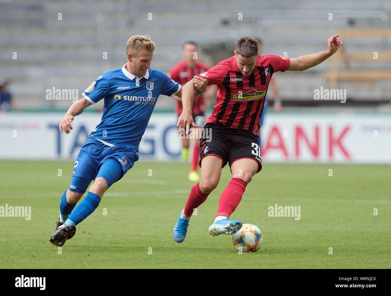 Magdeburg, Germania. 10 Ago, 2019. Calcio: DFB Cup, 1FC Magdeburg - SC Freiburg, 1° round in MDCC-Arena in Magdeburg. Magdeburg il Dominik Ernst (l) e Friburgo Christian Günter lotta per la palla. Credito: Peter Steffen/dpa - NOTA IMPORTANTE: In conformità con i requisiti del DFL Deutsche Fußball Liga o la DFB Deutscher Fußball-Bund, è vietato utilizzare o hanno utilizzato fotografie scattate allo stadio e/o la partita in forma di sequenza di immagini e/o video-come sequenze di foto./dpa/Alamy Live News Foto Stock