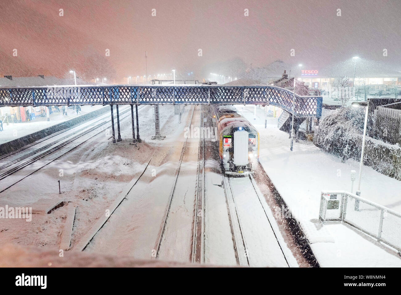 Tempesta di neve in Hampshire England.treno South West in attesa presso la stazione di gancio per le tracce di essere cancellato. Foto Stock