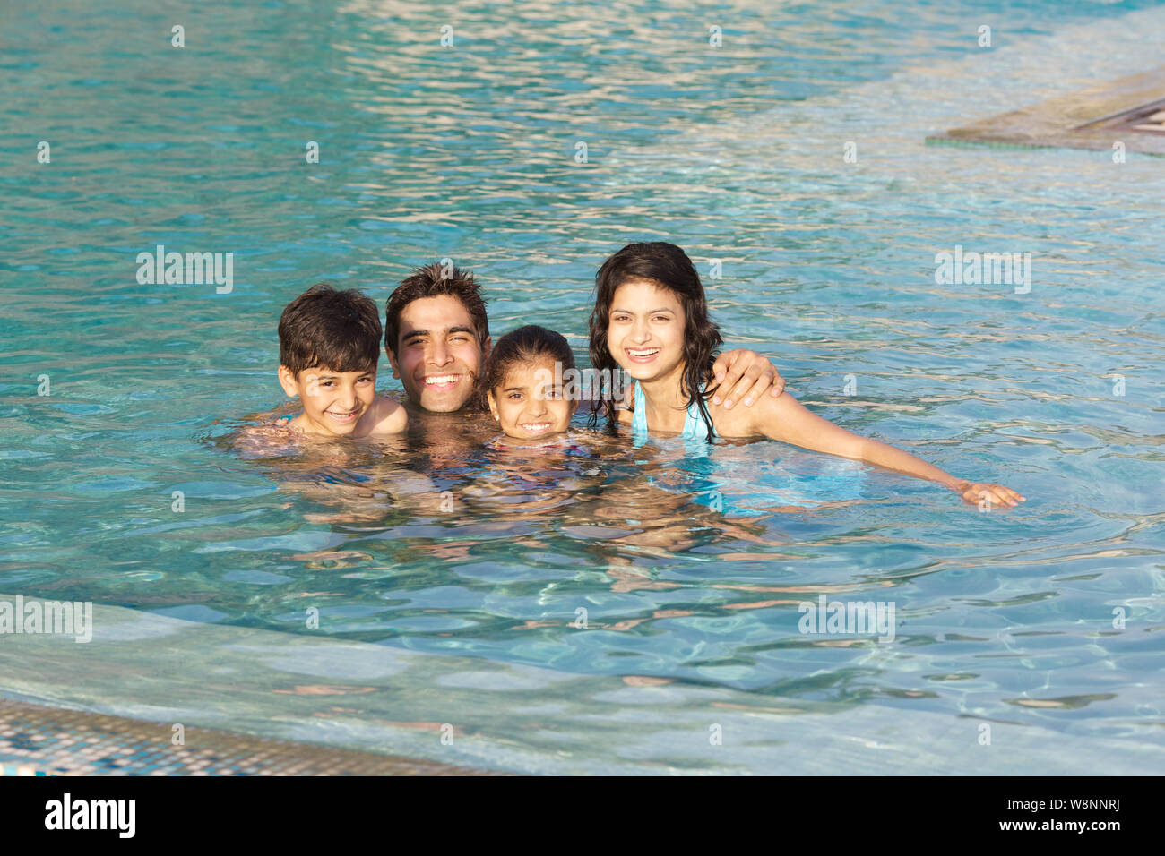 Famiglia godendo in una piscina Foto Stock