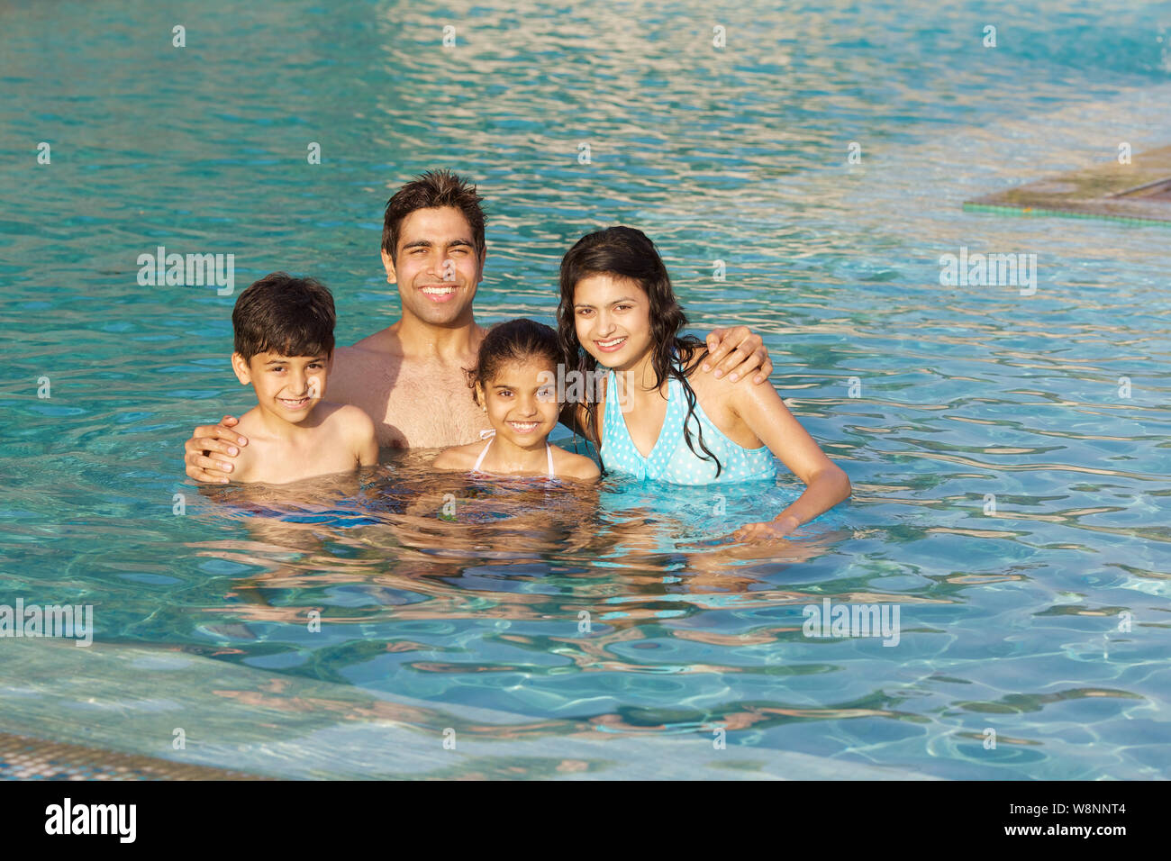 Famiglia godendo in una piscina Foto Stock