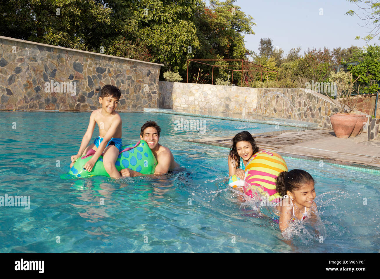 Famiglia che gioca in piscina Foto Stock