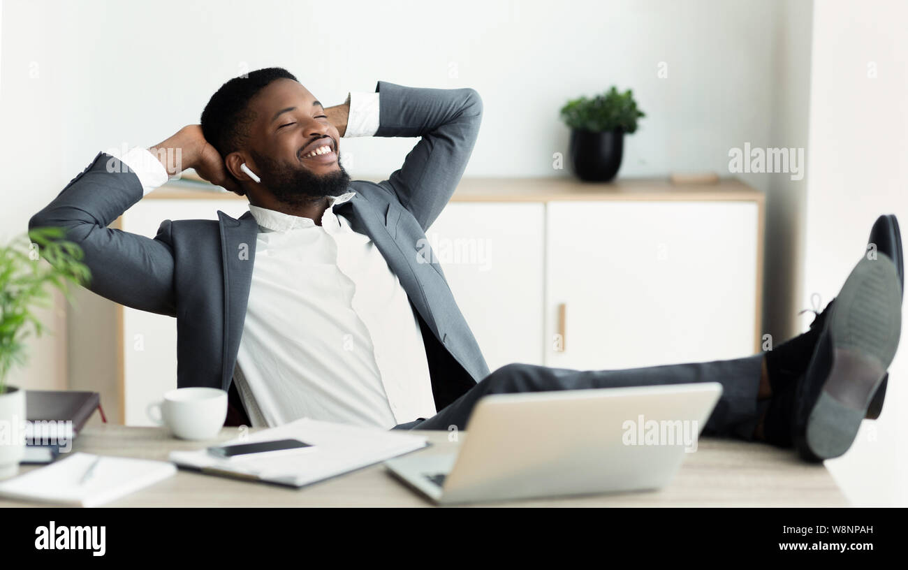 Giovane imprenditore rilassata piace ascoltare musica in ufficio. Foto Stock