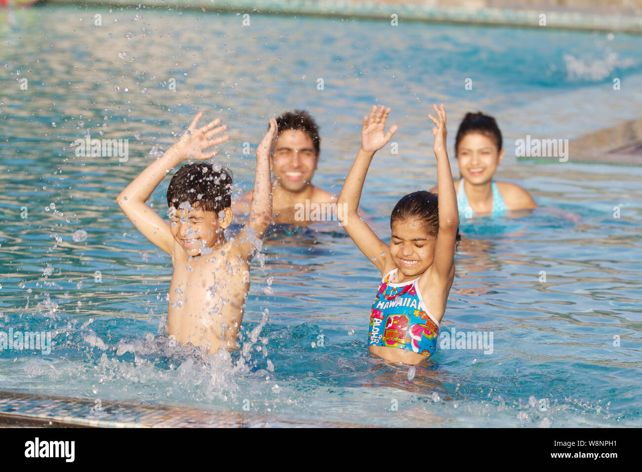 Famiglia che gioca in piscina Foto Stock