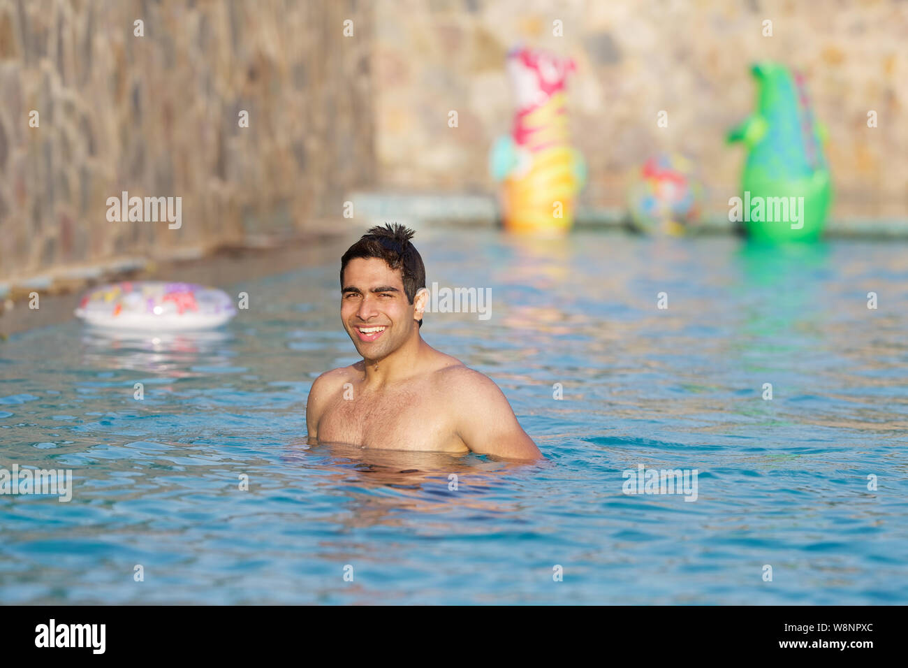 Giovane uomo godendo di una piscina Foto Stock