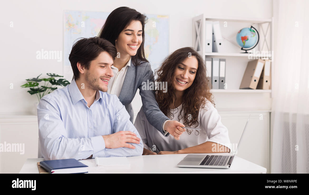 Agente di viaggio di lavoro con i clienti e offrire loro tours Foto Stock