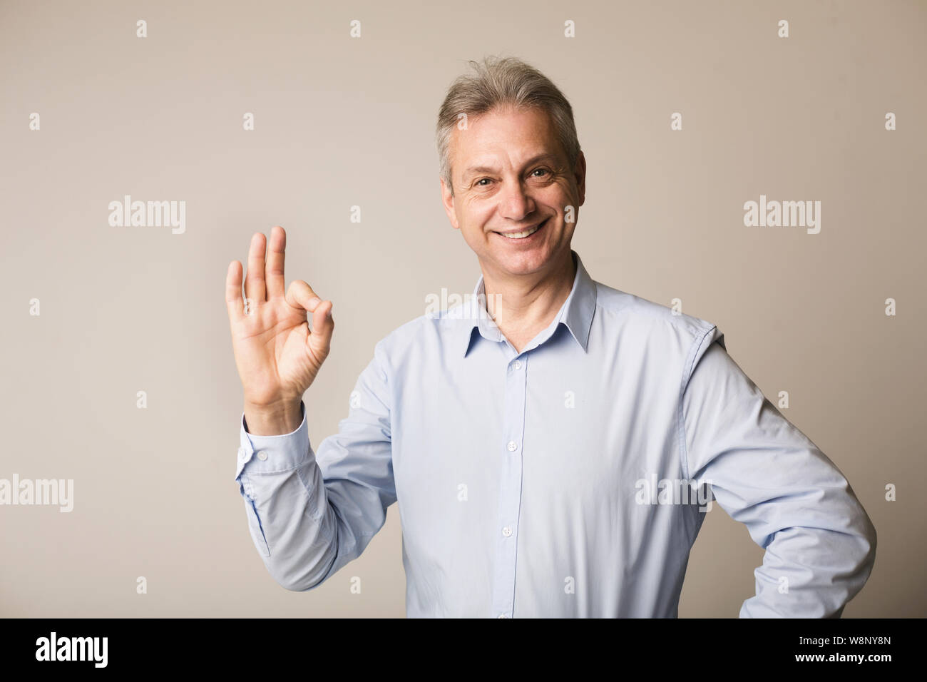Uomo maturo che mostra ok segno, guardando la fotocamera Foto Stock