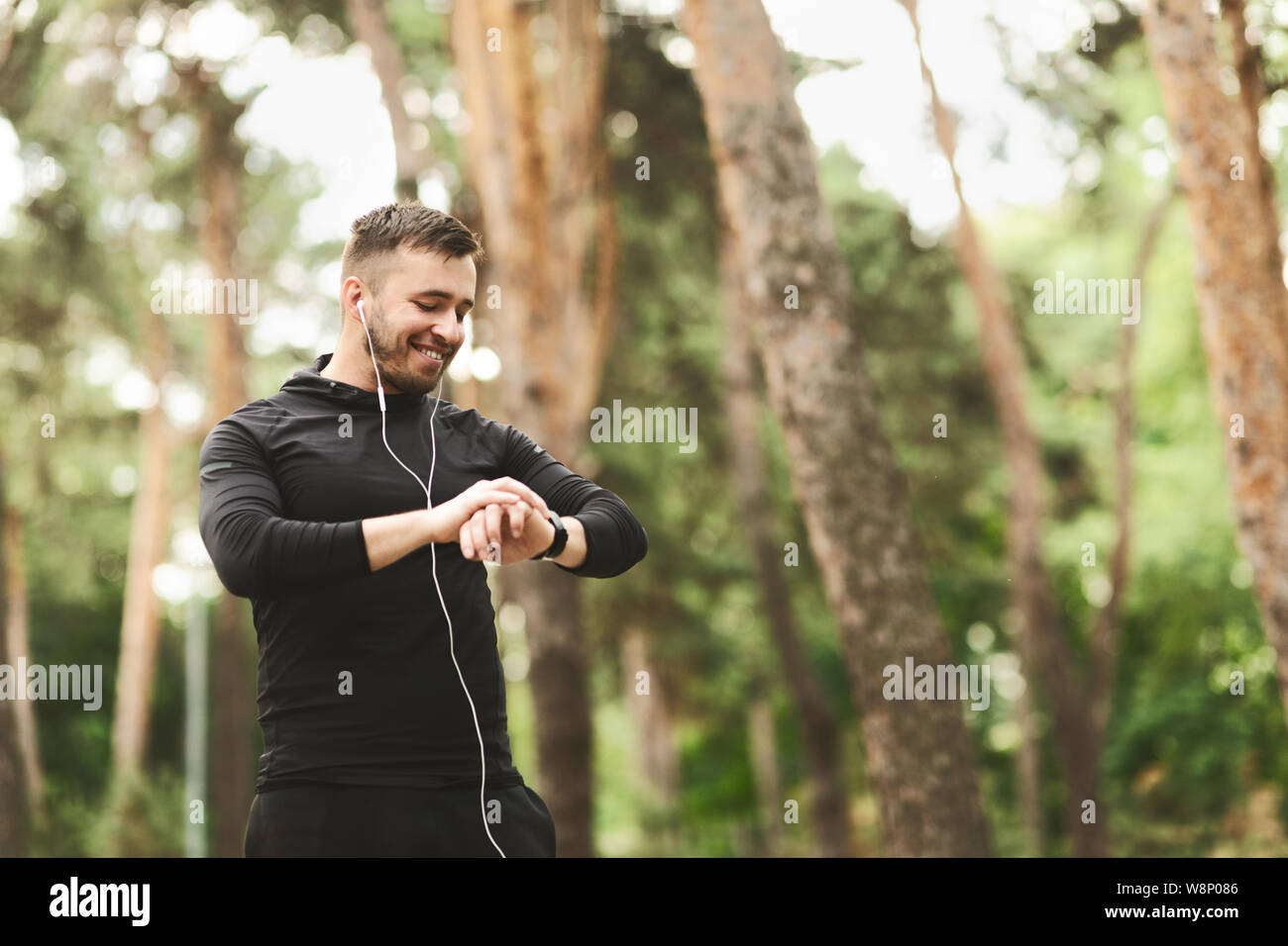 Runner maschio utilizzando smart watch per monitorare le sue prestazioni. Foto Stock
