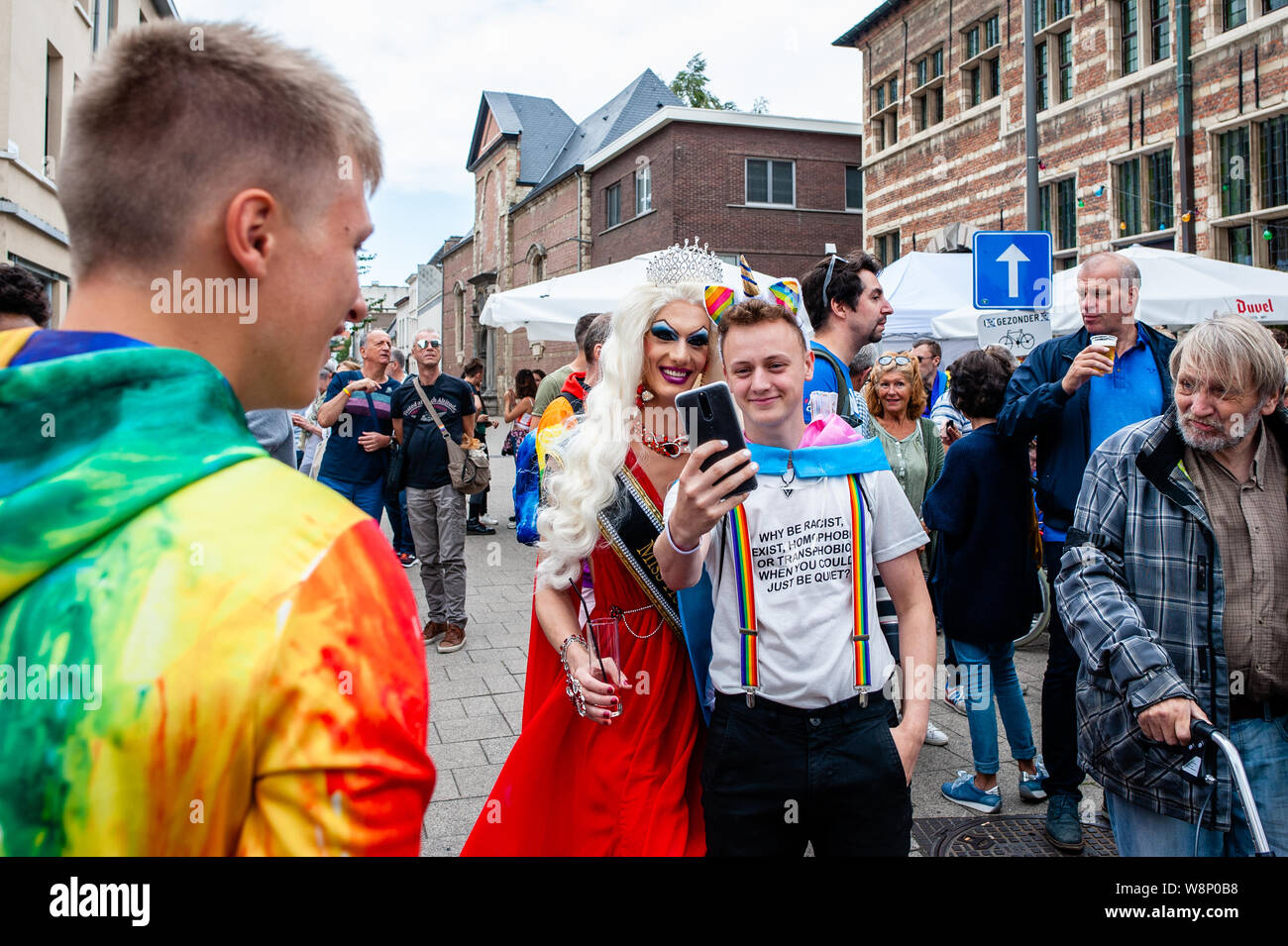 Una drag queen prende una foto con un giovane uomo durante la sfilata.Antwerp Pride commemora e celebra il lungo cammino in avanti l'accettazione e la parità di opportunità di LGBT+ comunità ha reso. Anversa orgoglio attira migliaia di persone per la città ogni anno. Foto Stock