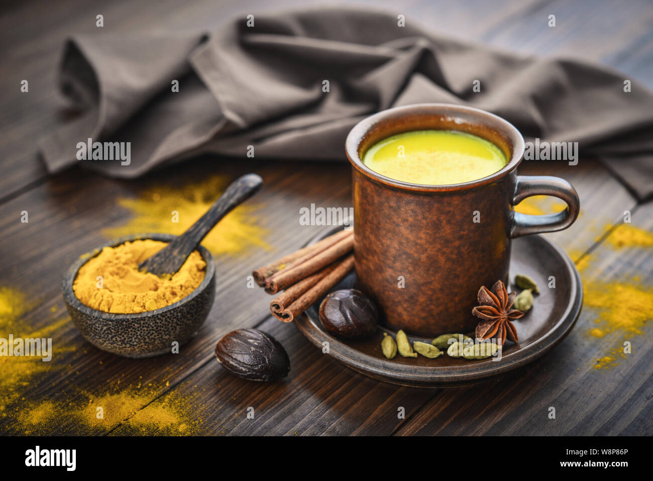 Tradizionale bevanda indiana curcuma latte è latte dorato con cannella,  chiodi di garofano e pepe e curcuma su uno sfondo di legno con spezie Foto  stock - Alamy