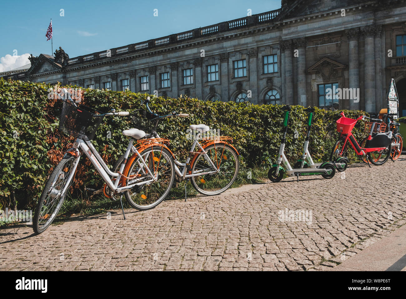 Berlino, Germania - Giugno, 2019: elettrica e scooter , escooter o e-scooter e bike sharing bicicletta sul marciapiede in Berlin Foto Stock