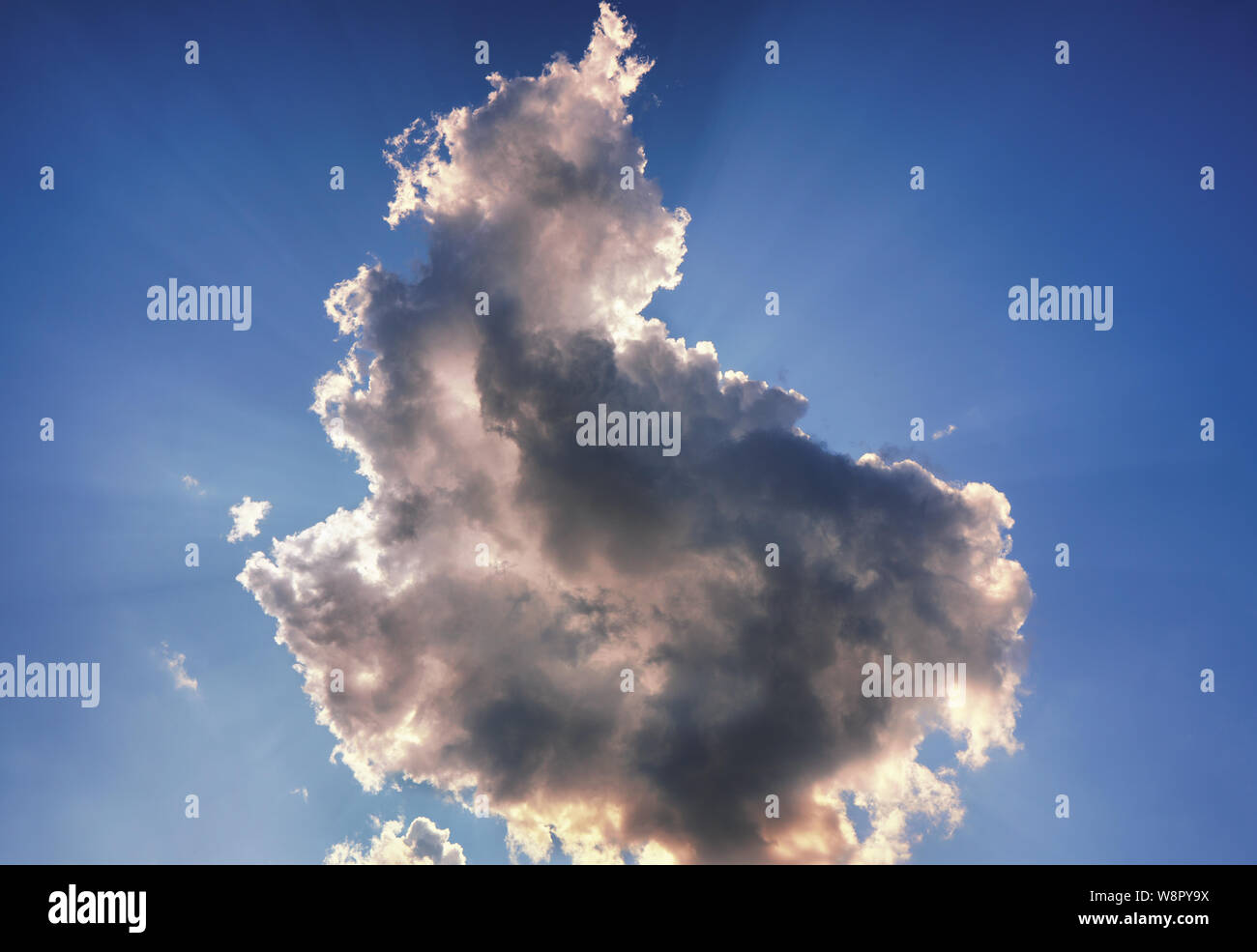 Sun dietro le nuvole contro un cielo blu. Nuvole che bloccano il sole può avere un 'Silver fodera'. Foto Stock