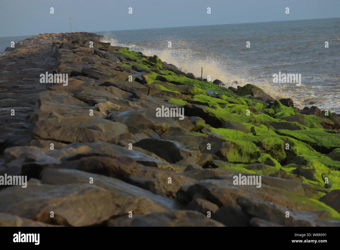 Le grandi rocce sotto forma di una linea verso il mare Foto Stock