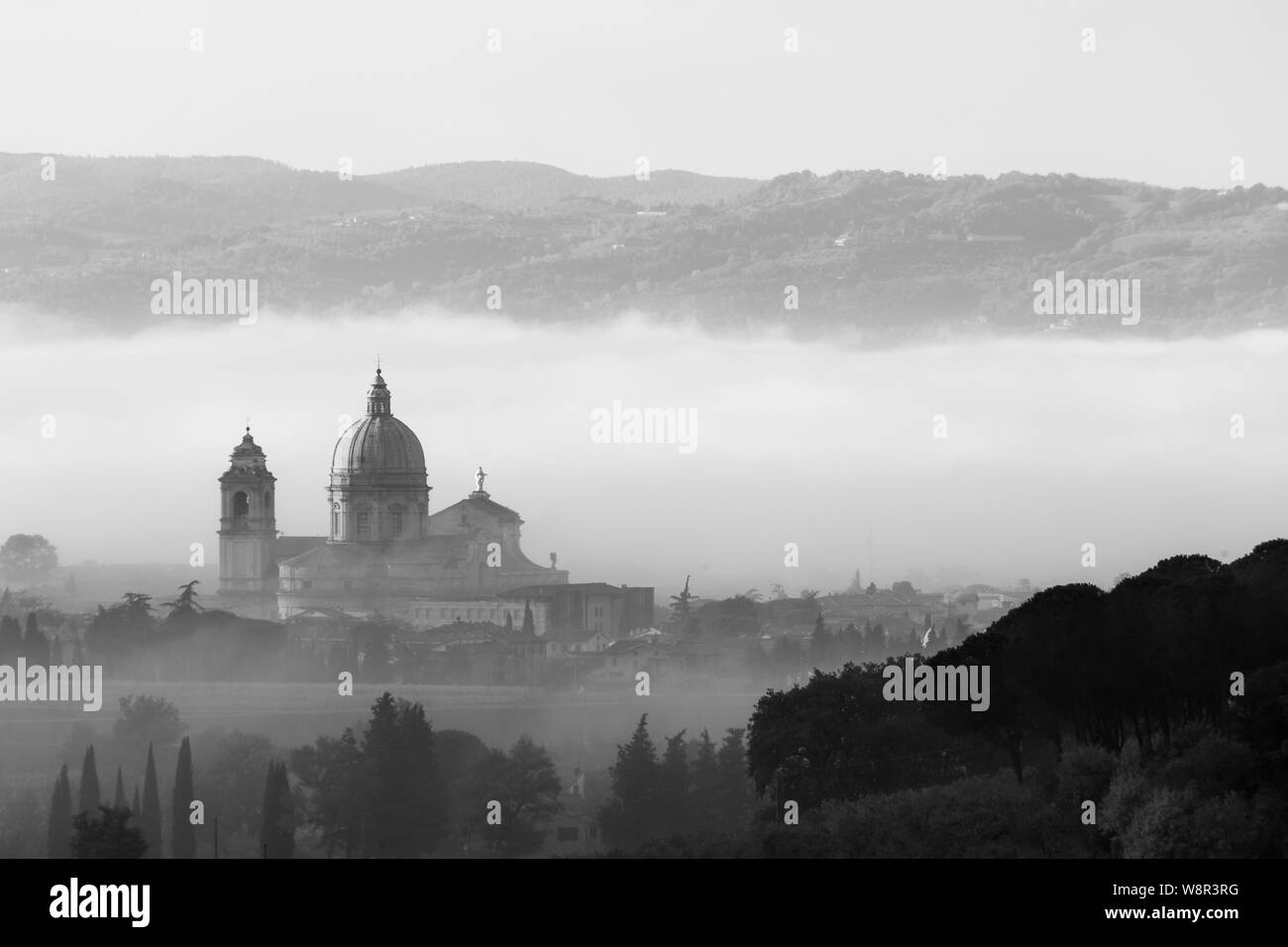 Vista su Santa Maria degli Angeli chiesa papale (Assisi) nel mezzo della nebbia Foto Stock