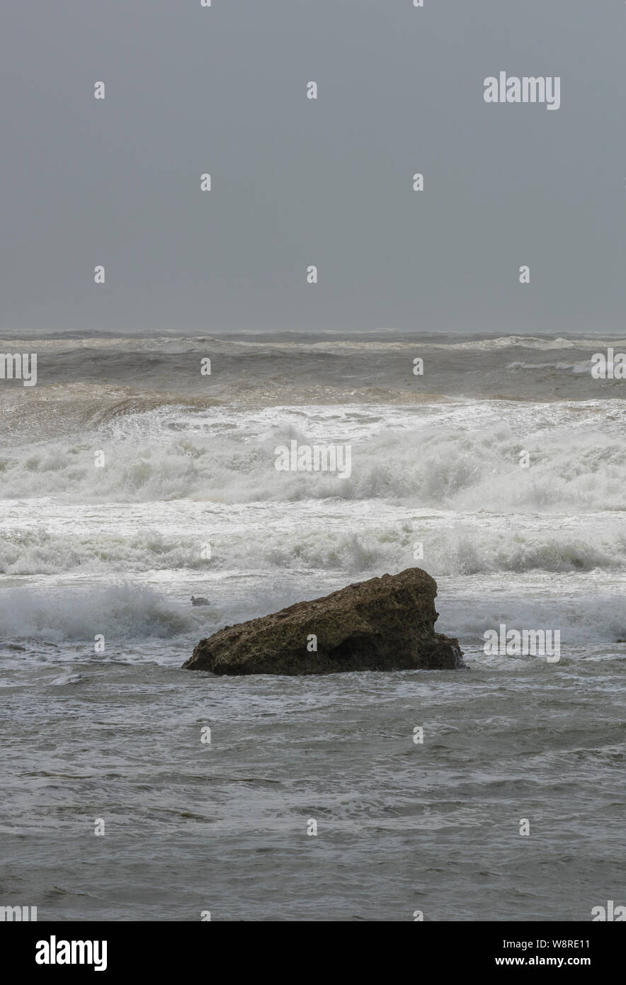 Condizioni meteorologiche avverse, tempestose e selvagge nella stagione invernale che si infrangono su rocce sulla riva della baia di acqua dolce sull'isola di Wight, regno unito. Foto Stock
