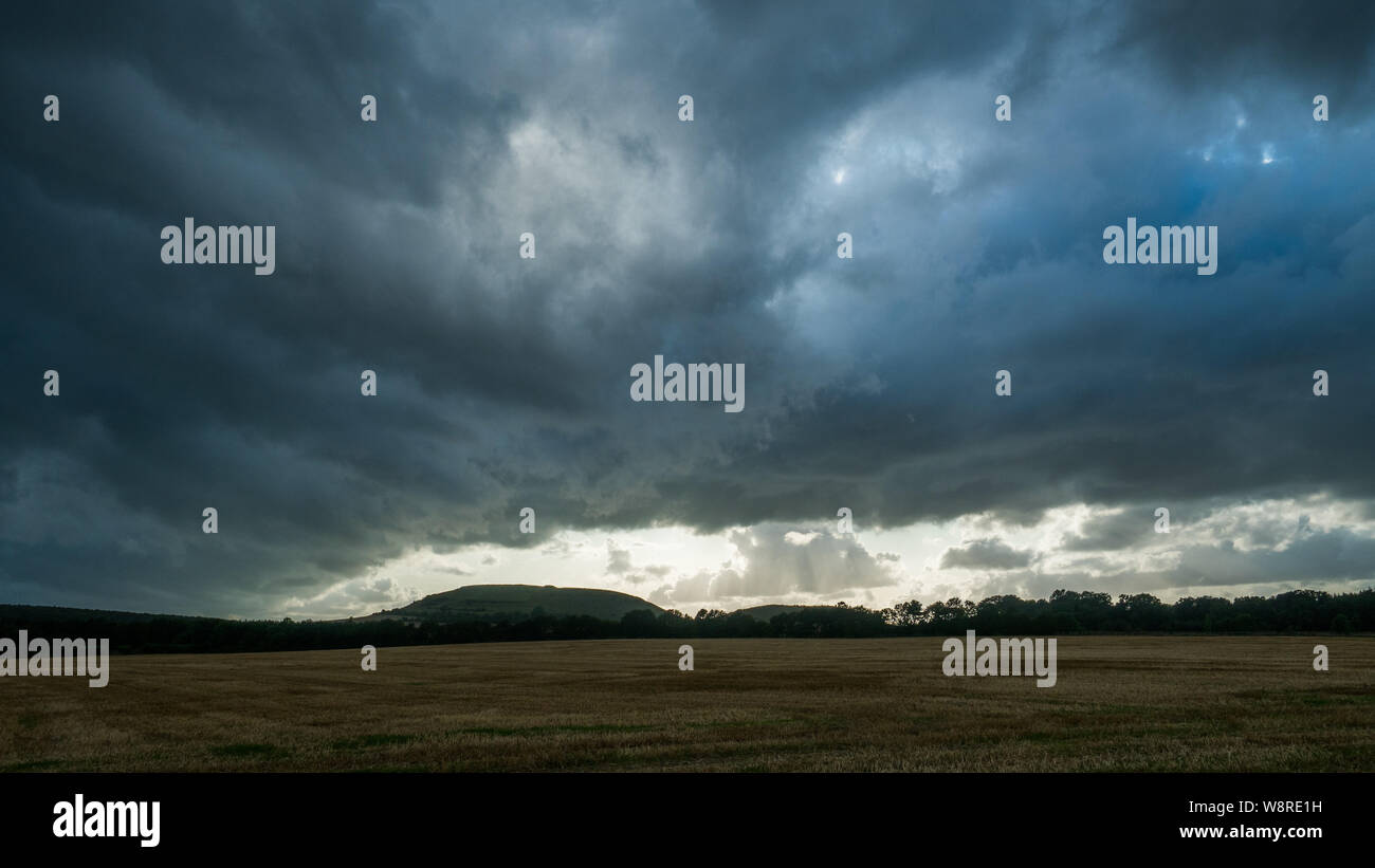 Un cielo tempestoso oltre Cley Hill, Warminster, Wiltshire, su una sera di agosto Foto Stock