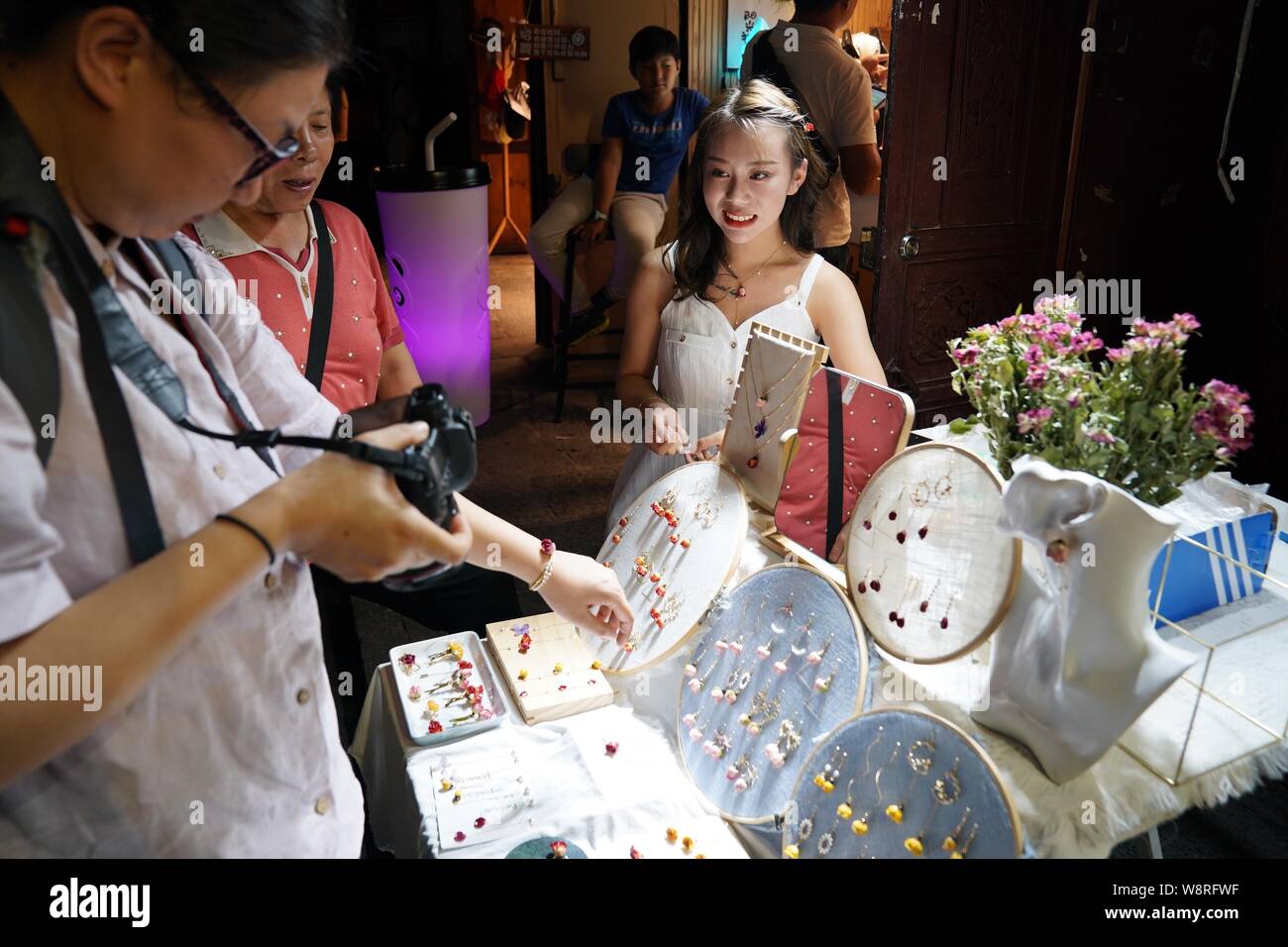 (190811) -- DALI, 11 Agosto, 2019 (Xinhua) -- i turisti selezionare accessori presso un negozio nella città vecchia di Dali, a sud-ovest della Cina di Provincia di Yunnan, il 10 agosto 2019. I turisti sono venuti qui per godere di incantevole vista notturna il cibo locale e attraente prestazioni durante le ore notturne. (Xinhua/Qin Qing) Foto Stock