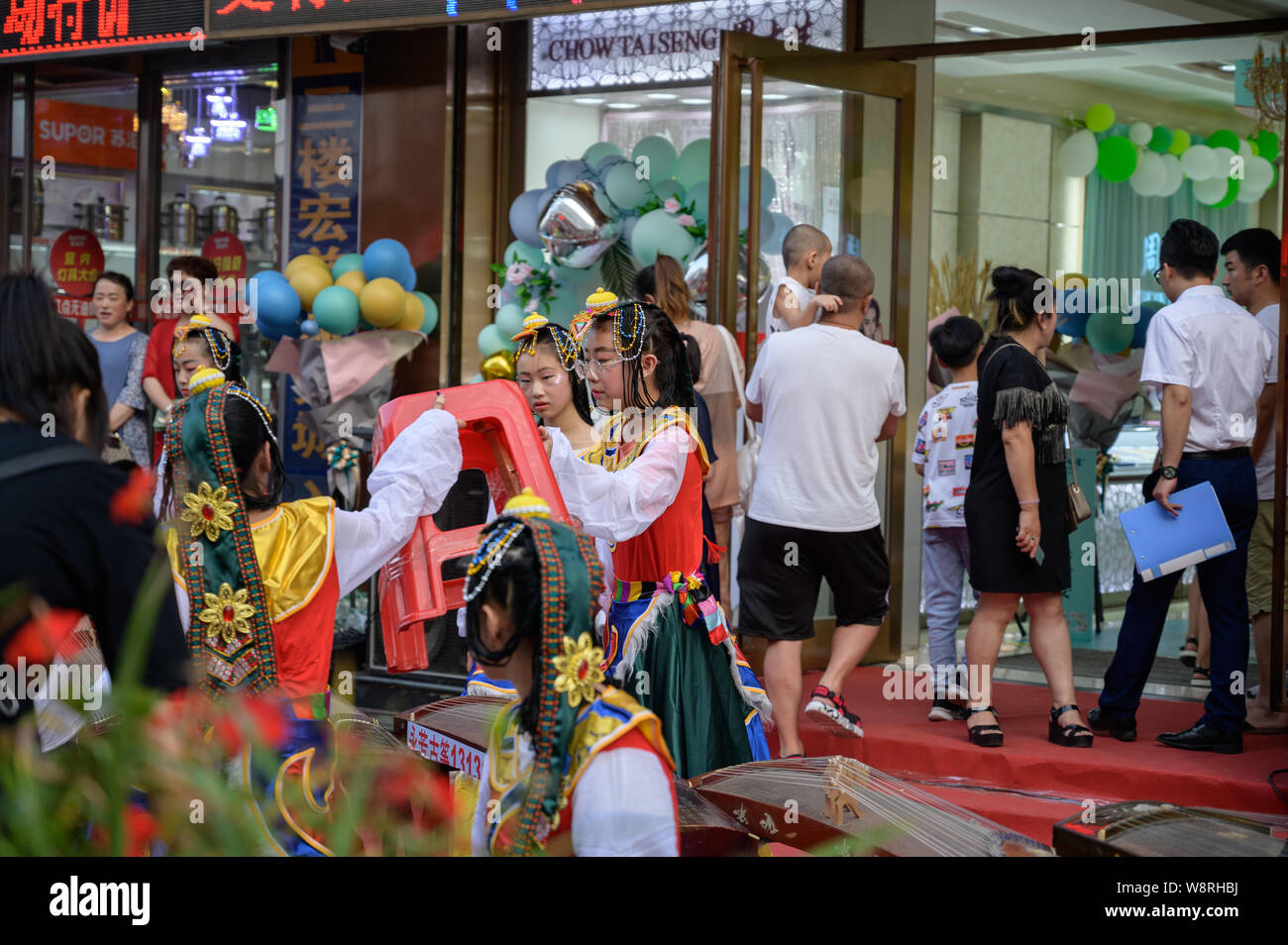 MISHAN, Cina - 28 luglio 2019: i bambini vestiti in cinese tradizionale costume cinese suona uno strumento musicale - GU Zheng. Foto Stock