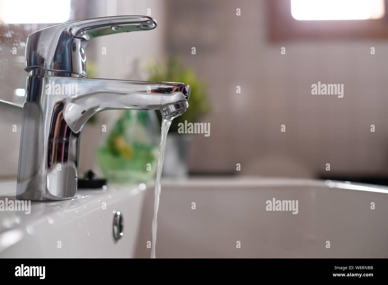 Aprire il rubinetto lavandino con acqua bassa pressione Foto Stock