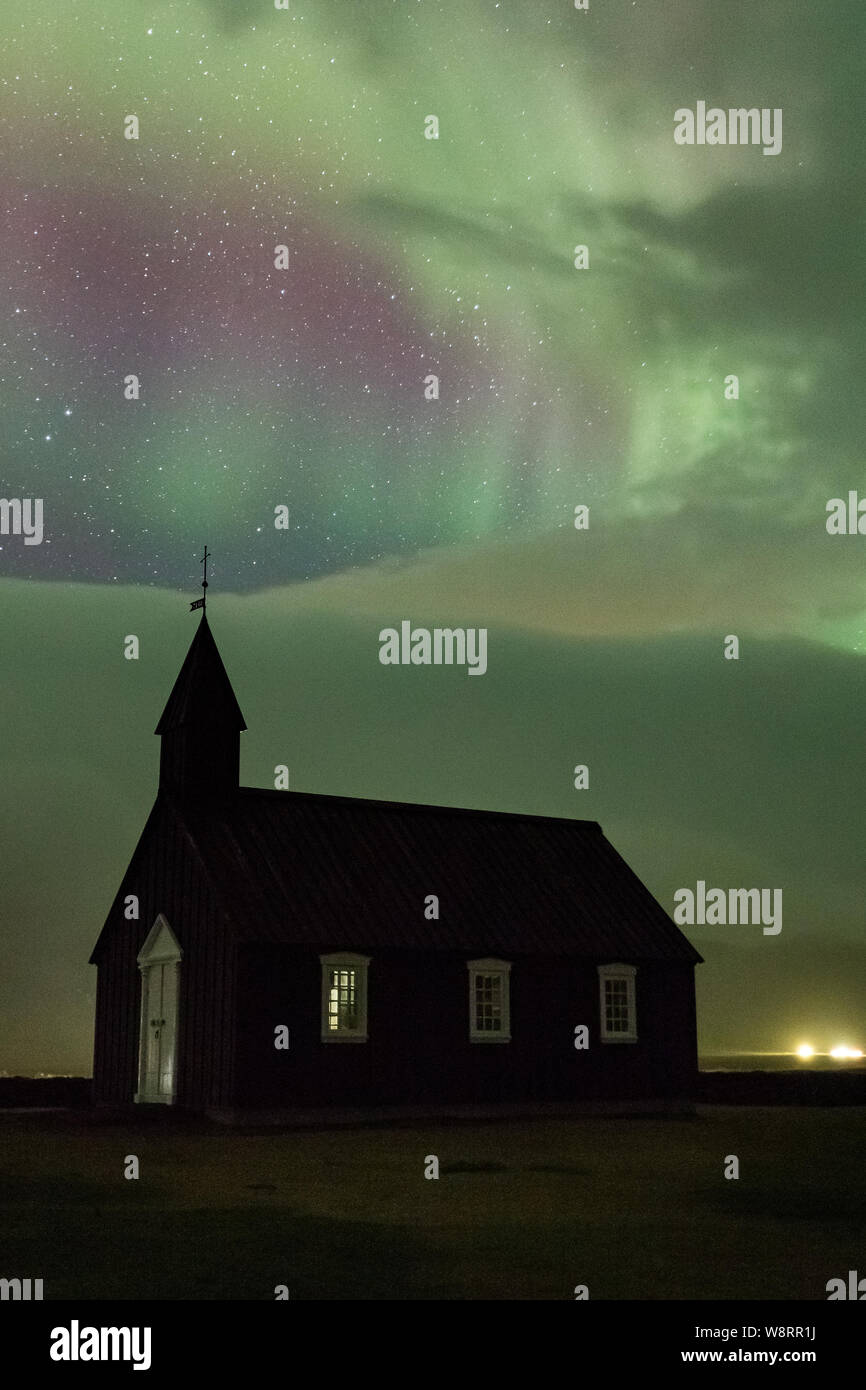 Islandese chiesa nera sotto le luci del nord Foto Stock