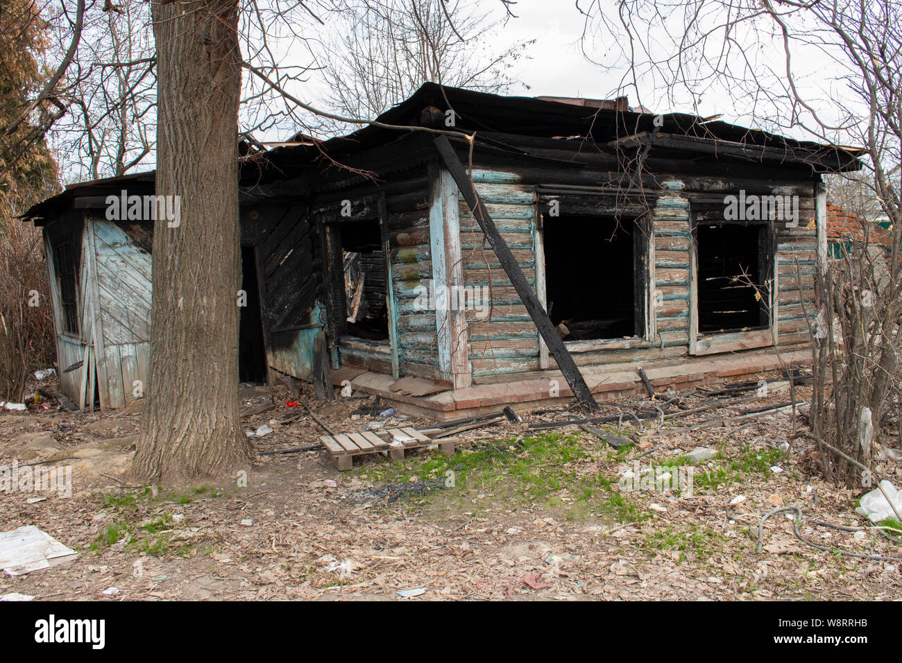 Di legno bruciato country house. Paese di residenza dopo un incendio. Carbonizzati nero pareti di vetro. Sfortuna, pericolo, incidente Foto Stock