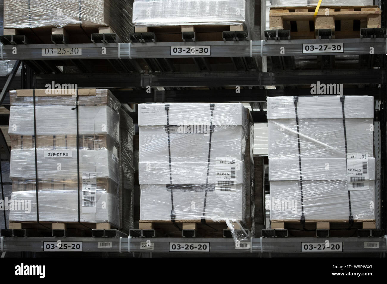 Magazzino con pallet di grandi dimensioni con scatole, partite di merci imballate in magazzino. Caselle bianche in pallet sugli scaffali di un grande magazzino store Foto Stock