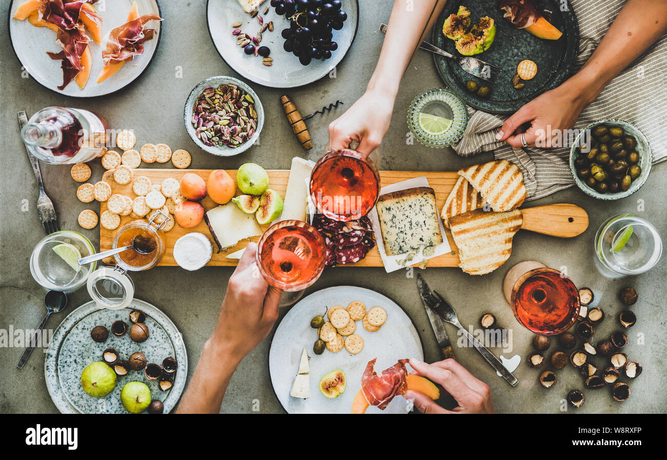 Salumi e formaggi, vino rosato, spuntini e i popoli mani Foto Stock