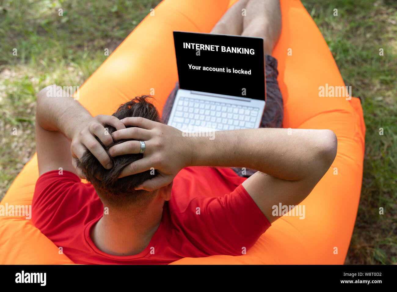 Il phishing online concetto, errore: internet banking. Il tuo accaunt è bloccato su uno schermo del notebook. allarmato uomo stringendo la sua testa Foto Stock