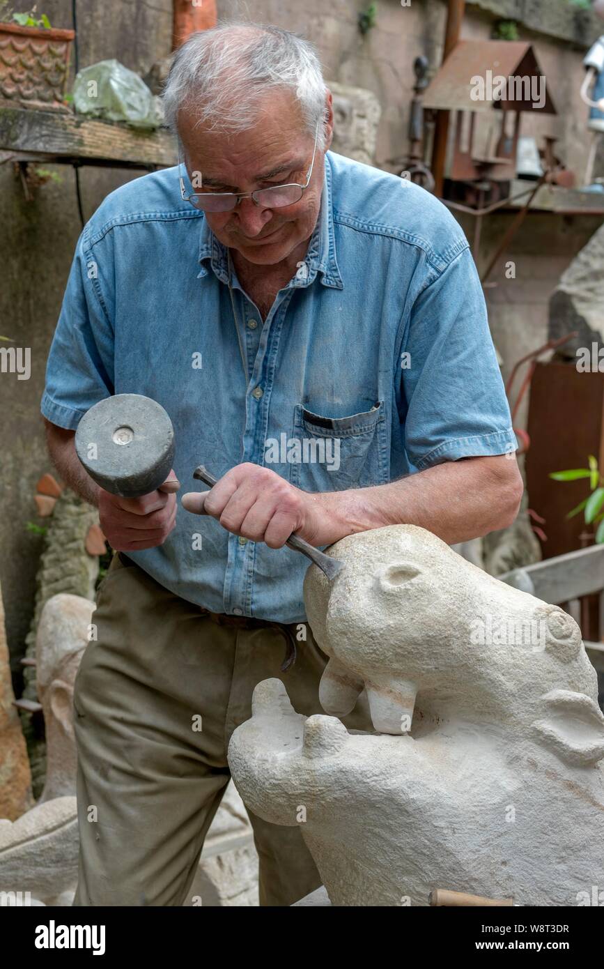 Scultore lavora con martello e scalpello su ippopotamo figura, Germania Foto Stock