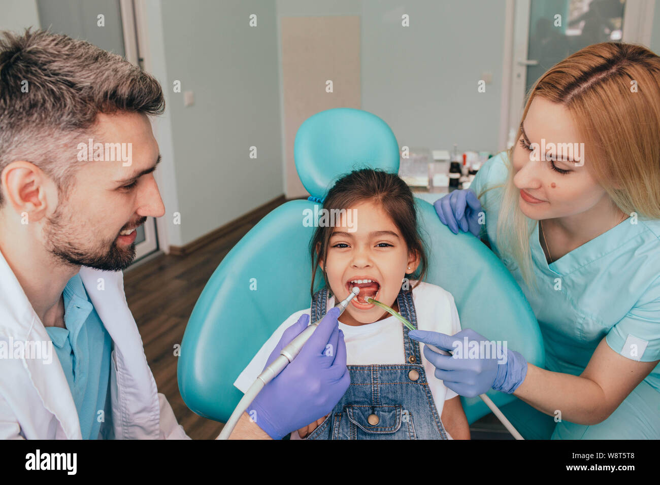 Assistenti aiutando dentista nel trattamento denti del paziente in Clinica Medica Foto Stock