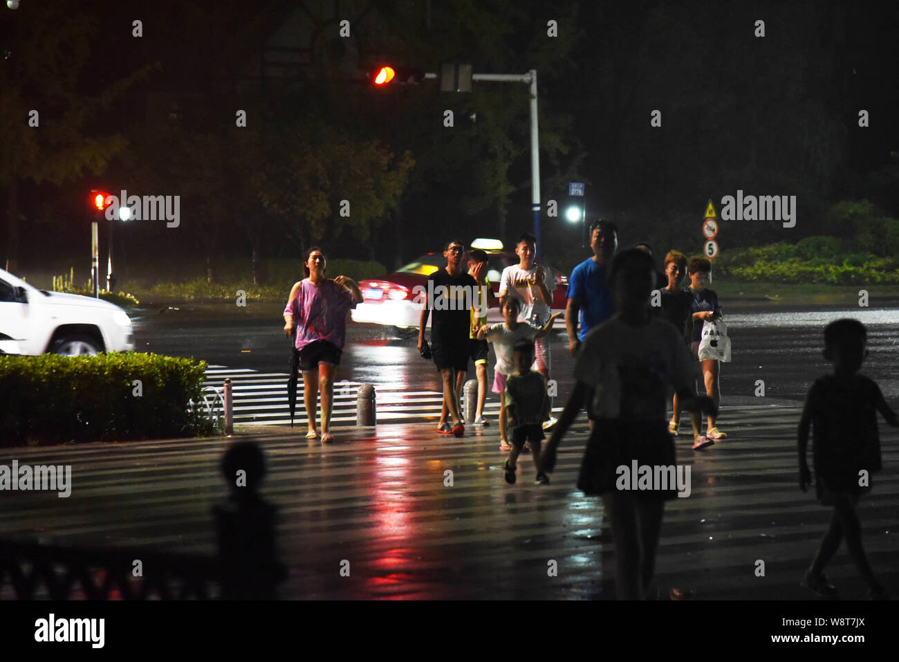 Jinan, la Cina della provincia dello Shandong. 11 Ago, 2019. La gente a piedi vicino alla costa nel distretto di Huangdao di Qingdao, Cina orientale della provincia di Shandong, 11 Agosto, 2019. Typhoon Lekima rende la sua seconda in atterraggio a 8:50 p.m. domenica sulla costa del distretto di Huangdao, la città di Qingdao, Cina orientale della provincia di Shandong, imballaggio si snoda fino a 82.8 km all'ora, secondo China Meteorological Administration. Credito: Wang Kai/Xinhua/Alamy Live News Foto Stock